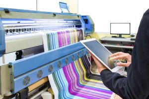 Máquina de impresión profesional produciendo material a color en comparación entre impresión offset vs impresión digital